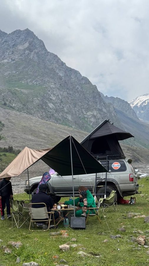 Family camp with rooftop tent and awning in a dramatic Kyrgyz valley